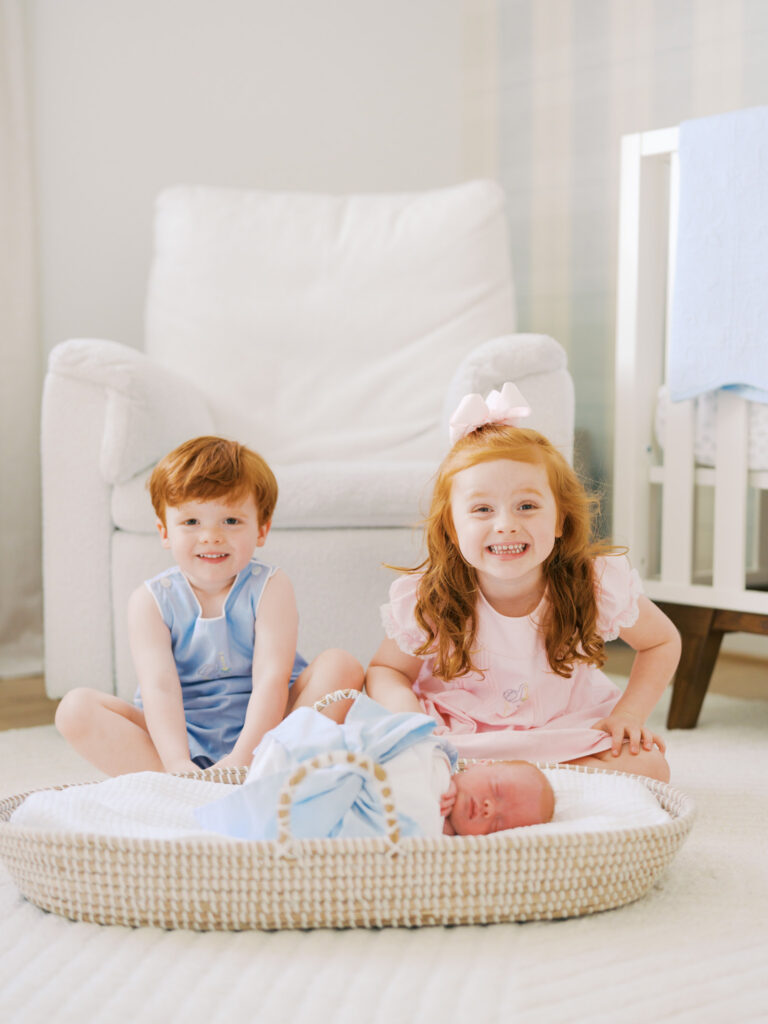 older siblings with little brother during newborn in home session in Dallas