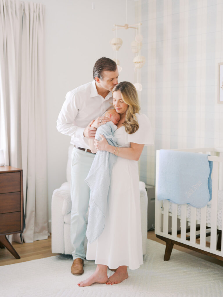 mom and dad embracing their baby boy during in home newborn session