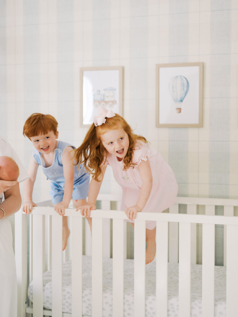 older siblings jumping in crib