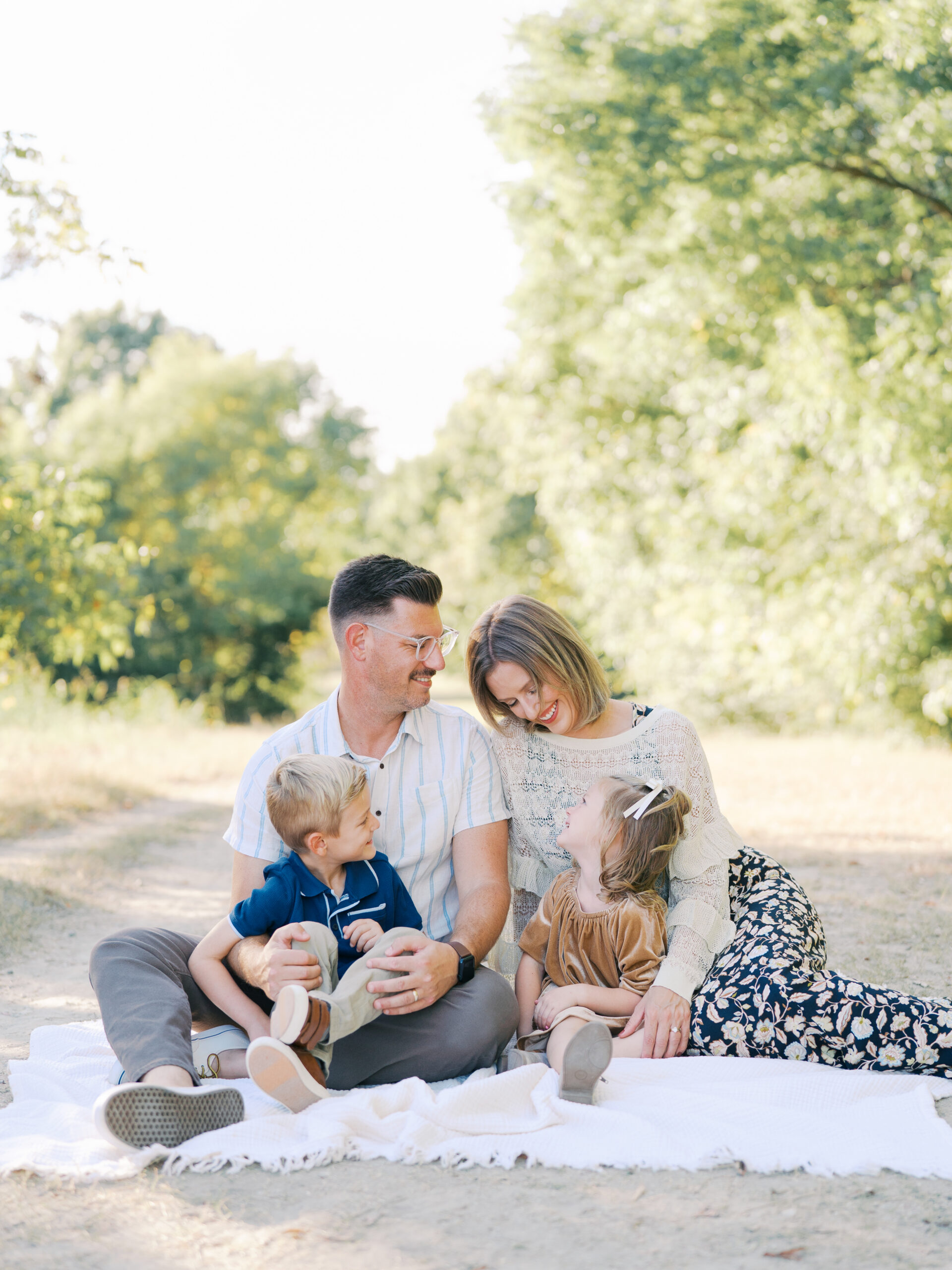 parents and kids sitting in a picnic blanket during their dallas spring family session